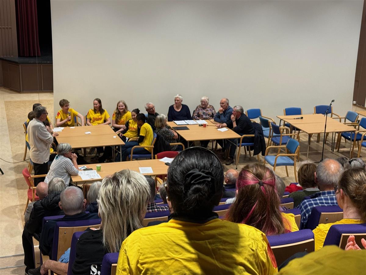 Flere personer sitter i en stor sal  - Klikk for stort bilde